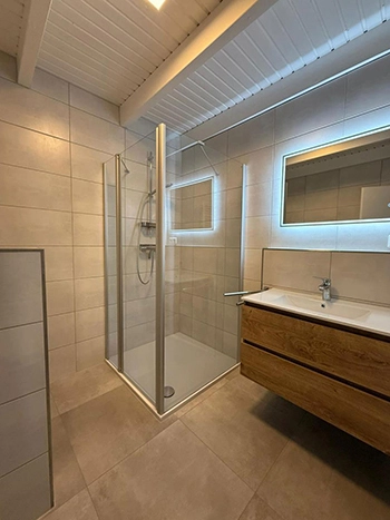 Badezimmer mit extra großer, ebenerdiger Dusche mit Duschhocker und Barrierearm 