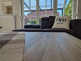 Helles Wohnzimmer mit Fenster zur Terrasse