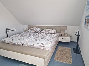 Doppelbett mit seitlichem Blick auf Nachttisch