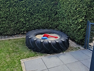 Sandkasten aus Reifen im Garten
