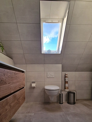 Modernes Badezimmer mit Dachfenster und WC