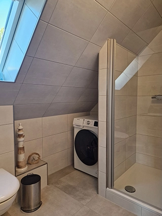 Badezimmer mit Dusche und Waschmaschine