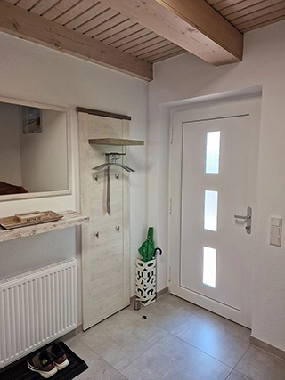 Moderner Eingangsbereich mit weißer Haustür und Garderobe