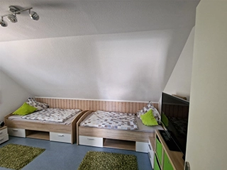Kinderzimmer mit zwei Einzelbetten und TV