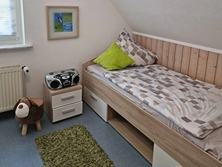 Einzelbett mit Nachttisch im Kinderzimmer