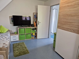 TV und Regal mit Spielen im Kinderzimmer