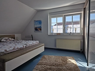 Schlafzimmer mit Doppelbett und TV