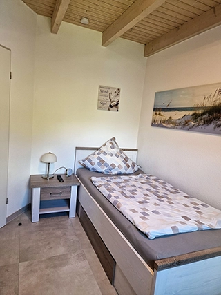 Helles Schlafzimmer mit Einzelbett und Nachttisch