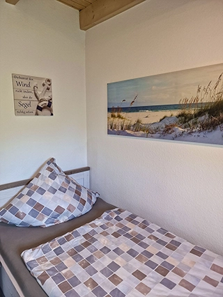 Einzelbett mit maritimer Wanddekoration im Schlafzimmer