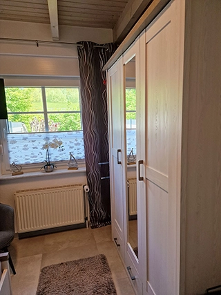 Schlafzimmer mit Kleiderschrank und Fenster