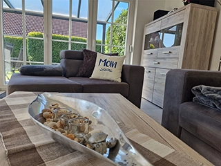 Gemütliches Wohnzimmer mit Sofa und Blick in den Garten