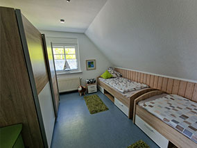 Einzelbett mit Nachtleuchte und Tisch